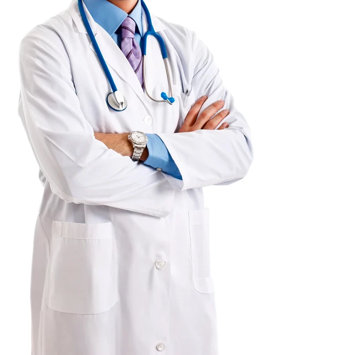Un médecin souriant aux cheveux afro volumineux, bras croisés, porte une blouse blanche et un stéthoscope vert autour du cou