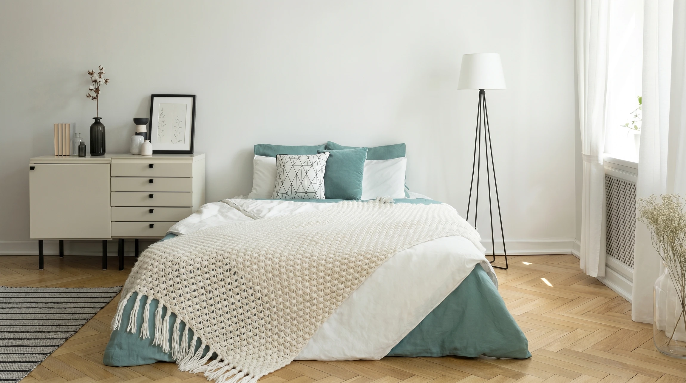 Une femme arrange soigneusement la literie d'un lit dans une chambre au style moderne