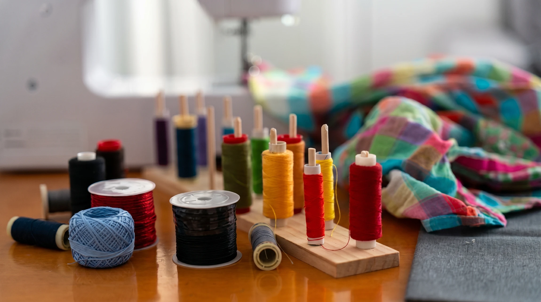 Scène d'atelier de couture avec ciseaux de tailleur ouverts et bobines de fil colorées disposées sur tissu orange à pois blancs